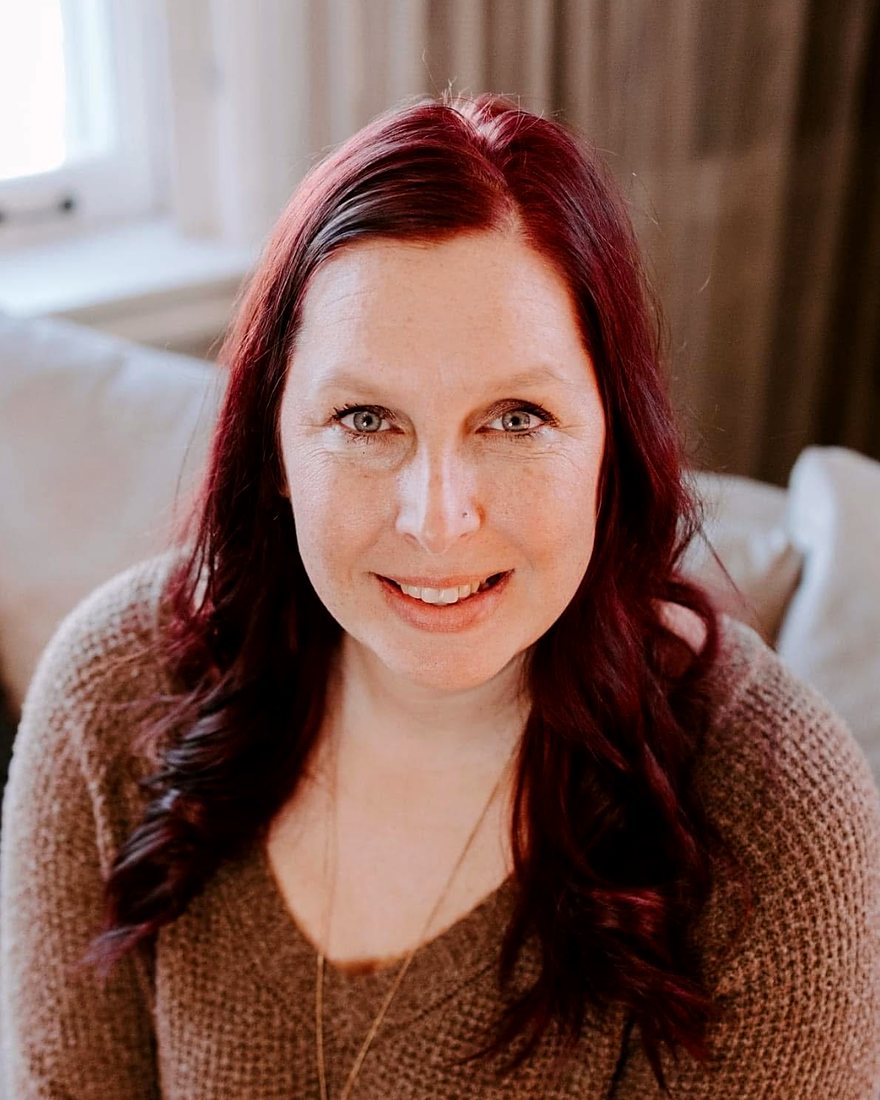 Molly Feit, founder of AM Financial, smiling in a sweater indoors